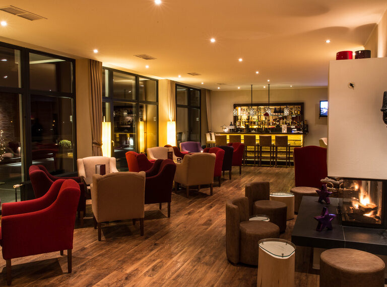 Ein stilvoll eingerichtetes Kamin-Lounge-Bar im Hotel mit gemütlichem Club Chair.