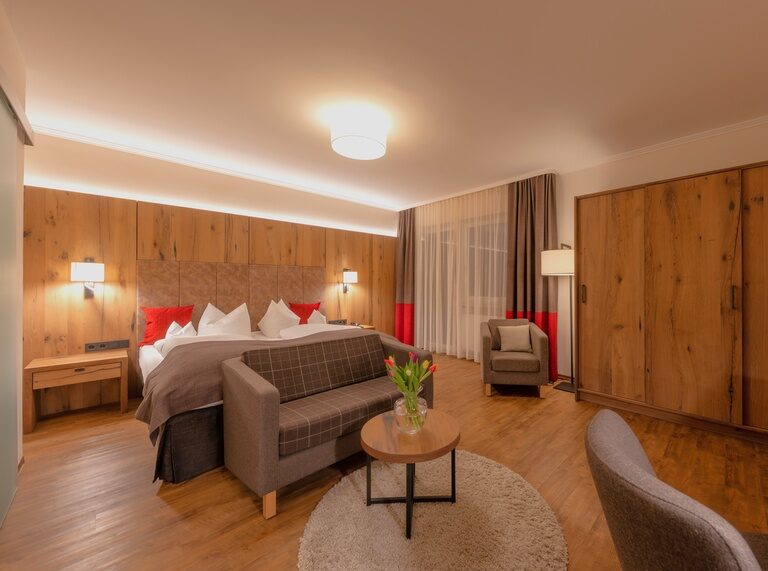 Ein einladendes Hotelzimmer mit einem eleganten Doppelbett und klassischen Holzmöbeln.