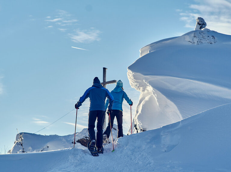 Eine Gruppe von Schneeschuhwanderer erreicht den Gipfel im Bayerischen Wald